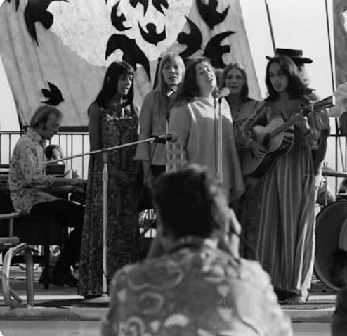 (Left to Right): Stephen Stills, Mimi Fariña, Joni Mitchell, Cass Elliott, Judy Collins, Joan Baez with David Crosby behind her, Big Sur Folk Festival, September 1968. [Siquomb]
