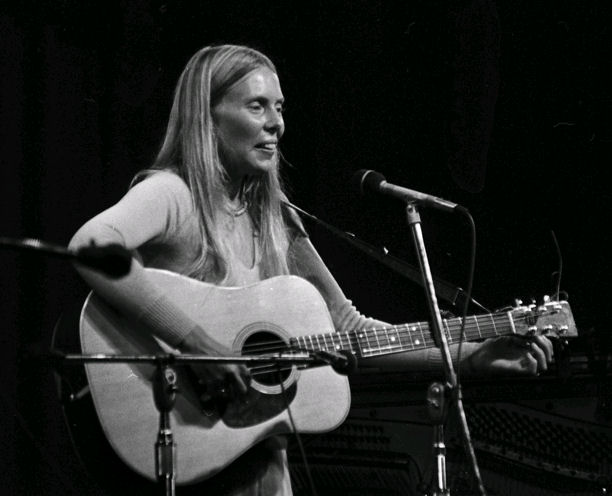 Joni tuning her guitar on stage.<br>Photo by Norm Betts. 