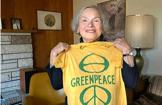 Dorothy Stowe holds-up an original Greenpeace T-shirt. 