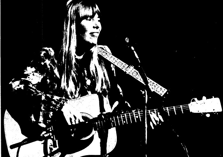 Photo from the University of British Columbia's Ubyssey newspaper, taken by Kini McDonald. Caption reads: SMILING ECSTATICALLY while singing to 3,000 at the Queen E Wednesday night, Joni Mitchell thrilled audience with new songs.  