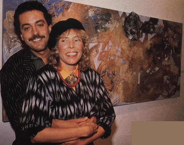 Larry Klein & Joni in front of her painting titled <i>The Basket Weavers</i>. 