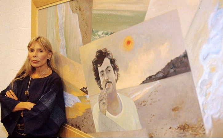 Joni stands next to her painting titled The Malibu Fire.  Photo by Peter Brooker. [Siquomb]