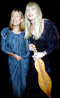 Joni & John Kelly, impersonator, with the dulcimer she presented him with in 1996 backstage at his <i>Paved Paradise</i> show.  Photo by Kevin Mazur.