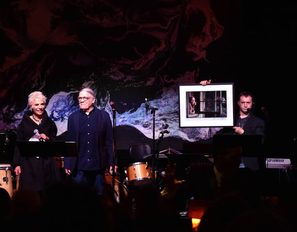 Henry Diltz auctioning off some of his photographs of Joni Mitchell signed by Joni Mitchell to Benefit The Jazz Foundation of America.  Photo by Lester Cohen [NYCRobert]